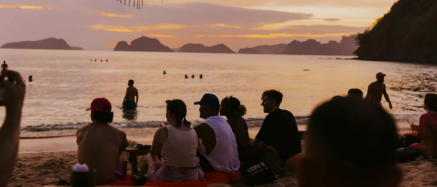 People Enjoying A Sunset At The Beach